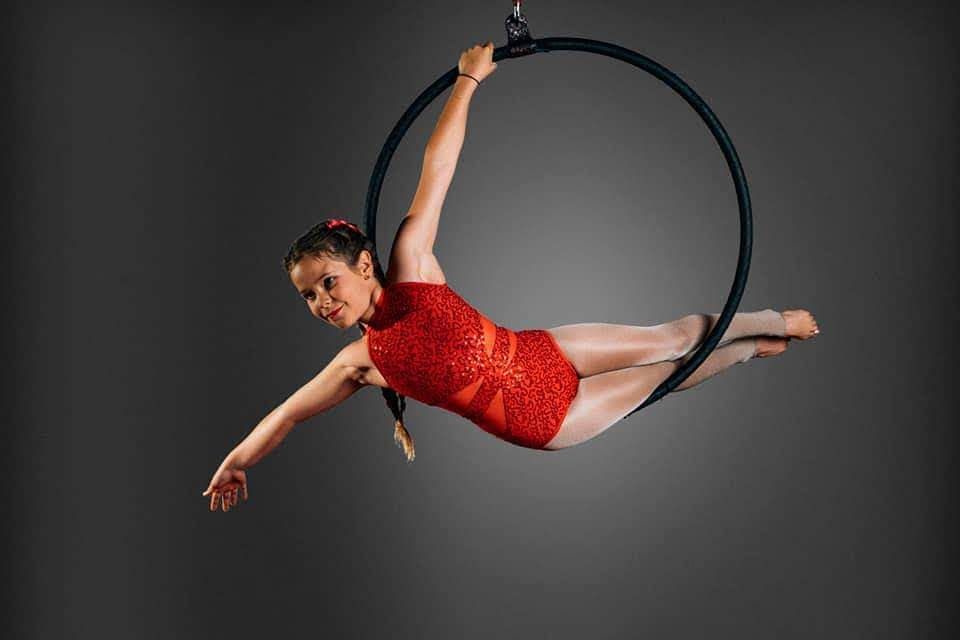 Junior student demonstrating cobra move on Lyra (Aerial Hoop)