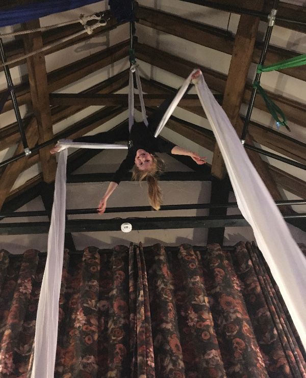 Junior student demonstrating a Crossback Straddle on Silks